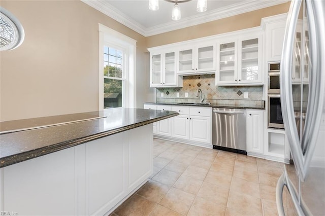 kitchen with sink, ornamental molding, appliances with stainless steel finishes, white cabinets, and backsplash