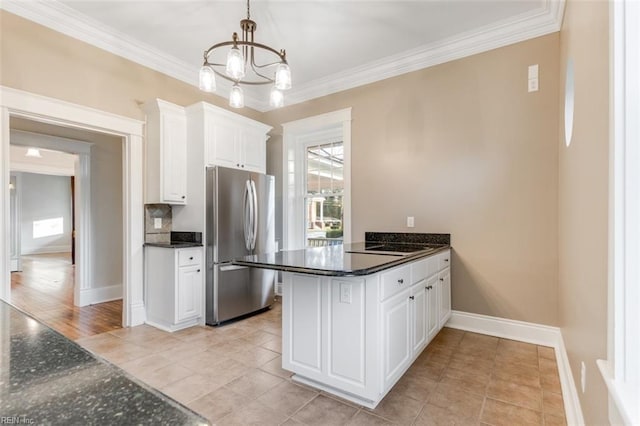 kitchen featuring white cabinetry, crown molding, hanging light fixtures, stainless steel refrigerator, and kitchen peninsula