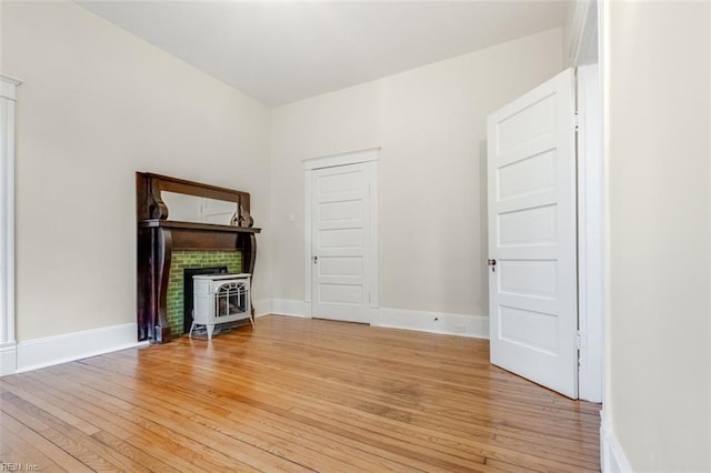 unfurnished living room with a wood stove and light hardwood / wood-style floors