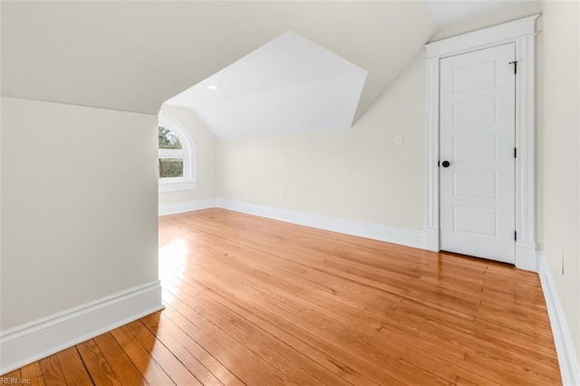 bonus room with lofted ceiling and light wood-type flooring