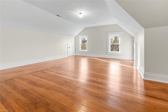 bonus room with vaulted ceiling and light hardwood / wood-style floors