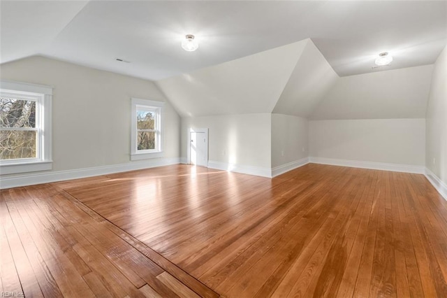 additional living space with vaulted ceiling and light hardwood / wood-style floors