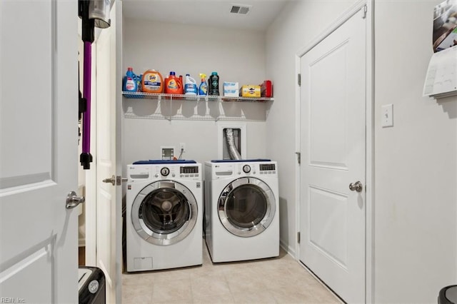 washroom featuring light tile patterned floors and washer and clothes dryer