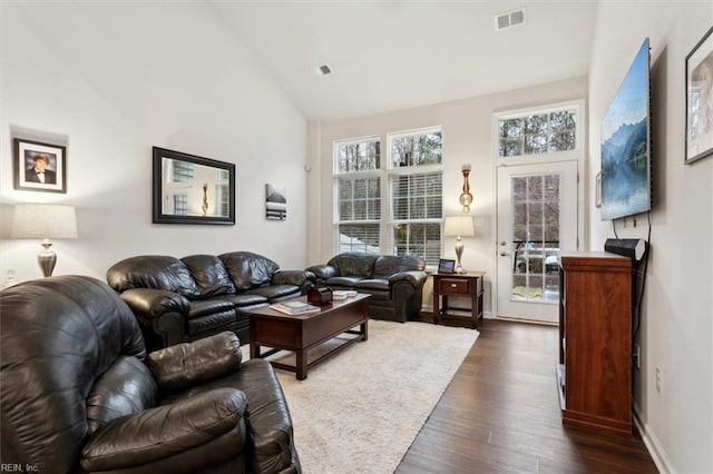 living room with dark wood-type flooring and high vaulted ceiling