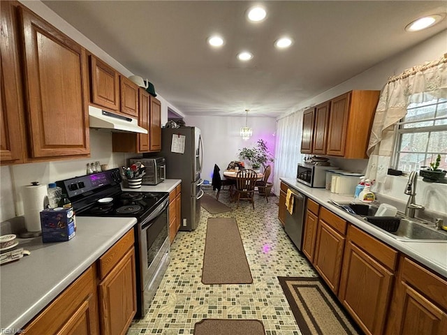 kitchen with an inviting chandelier, pendant lighting, stainless steel appliances, and sink