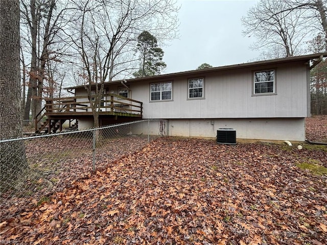 rear view of property with a wooden deck and cooling unit