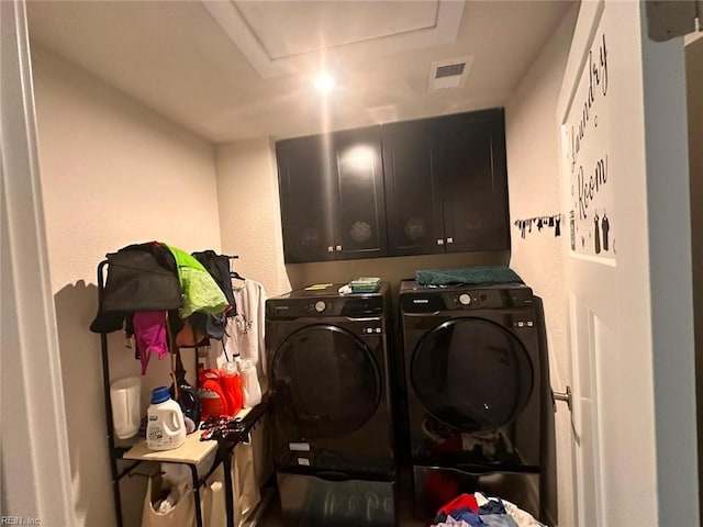 washroom featuring washer and dryer and cabinets