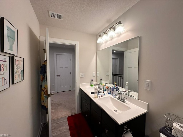 bathroom featuring a textured ceiling, vanity, and hardwood / wood-style flooring