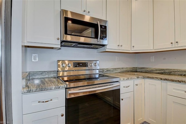 kitchen with light stone countertops, white cabinets, and appliances with stainless steel finishes