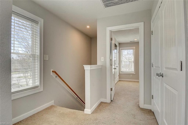 hall with light colored carpet