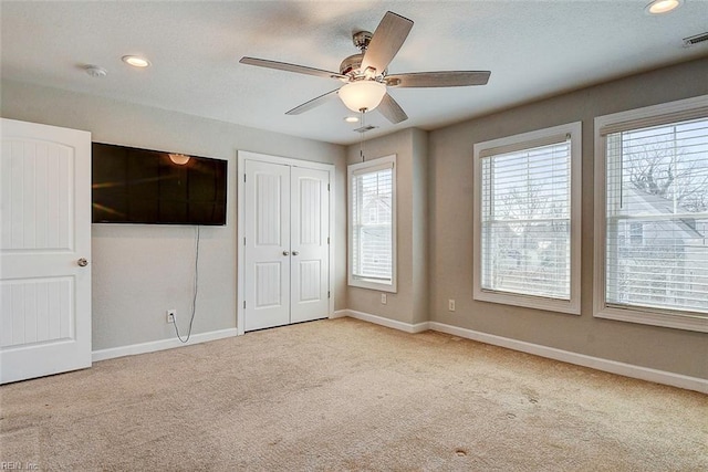 unfurnished bedroom with ceiling fan and light colored carpet