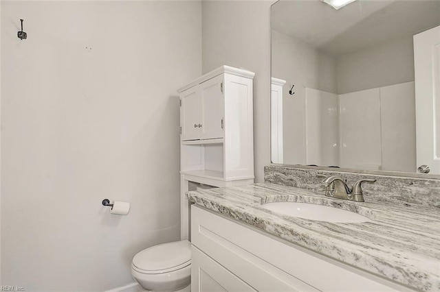 bathroom featuring vanity, a shower, and toilet