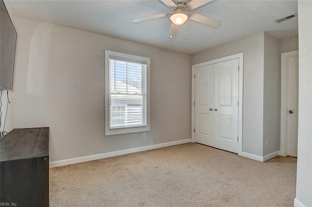 unfurnished bedroom with light carpet, ceiling fan, and a closet