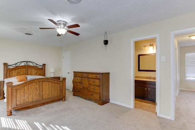 bedroom featuring connected bathroom, sink, light carpet, a textured ceiling, and ceiling fan