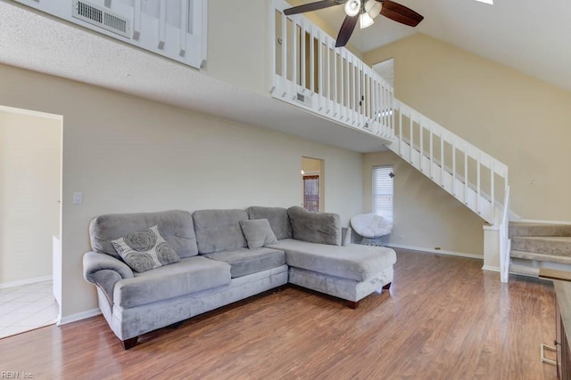 living room with ceiling fan, hardwood / wood-style floors, and high vaulted ceiling