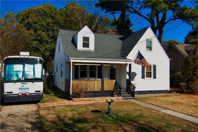 cape cod-style house featuring covered porch and a front lawn