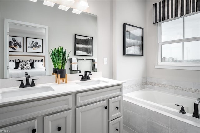 bathroom with vanity and a relaxing tiled tub