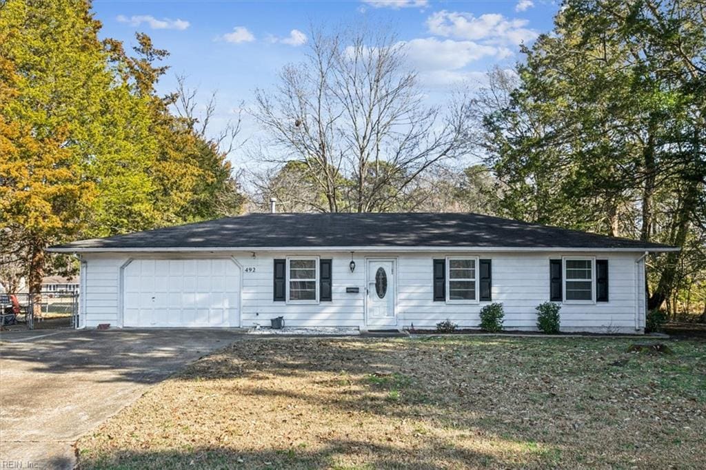 single story home featuring a garage and a front lawn