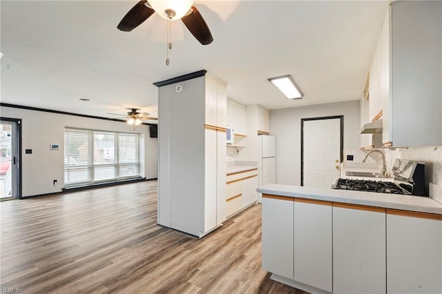 kitchen with white cabinets, white fridge, range, ceiling fan, and light wood-type flooring