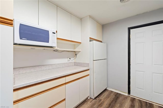 kitchen featuring white cabinetry, dark hardwood / wood-style floors, and white appliances