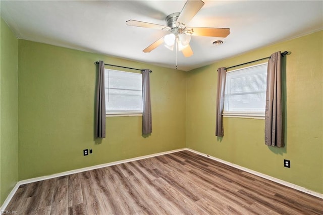 unfurnished room with wood-type flooring, a healthy amount of sunlight, and ceiling fan