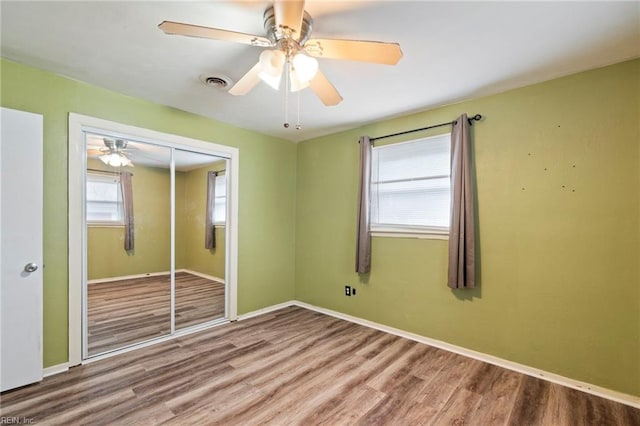 unfurnished bedroom featuring hardwood / wood-style flooring, ceiling fan, and a closet