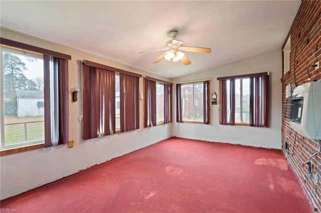 unfurnished sunroom featuring heating unit and ceiling fan