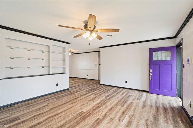 spare room with ceiling fan, ornamental molding, and light wood-type flooring