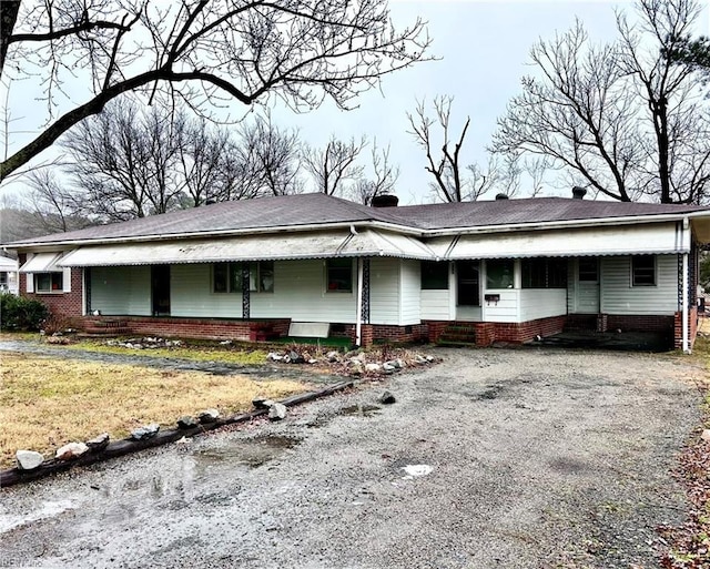 ranch-style home with entry steps and gravel driveway