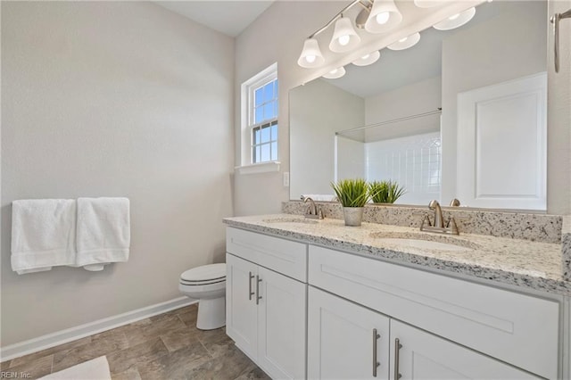 bathroom with vanity, toilet, and a shower