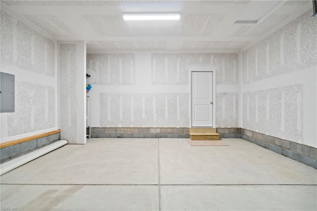 interior space with electric panel and concrete floors