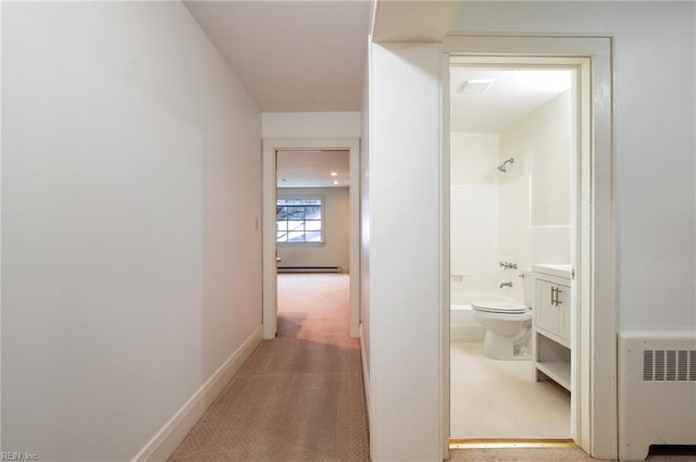 hall featuring light colored carpet, radiator heating unit, and a baseboard radiator