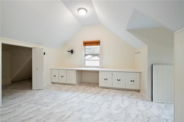 bonus room with built in desk and vaulted ceiling