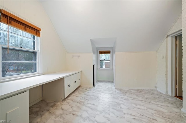 bathroom with vaulted ceiling and wooden walls