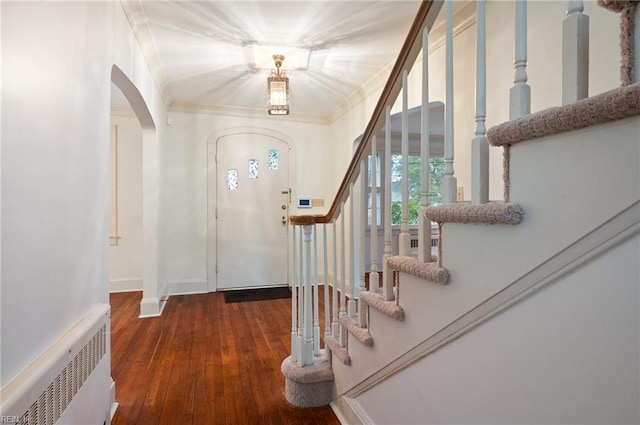 entryway with ornamental molding, radiator heating unit, and dark hardwood / wood-style flooring