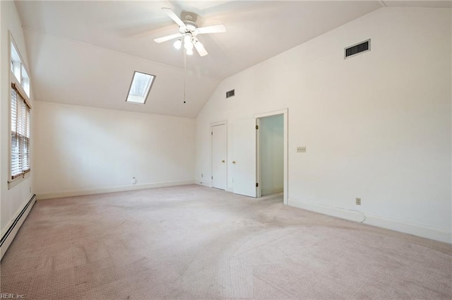 carpeted spare room with a baseboard radiator, high vaulted ceiling, ceiling fan, and a skylight