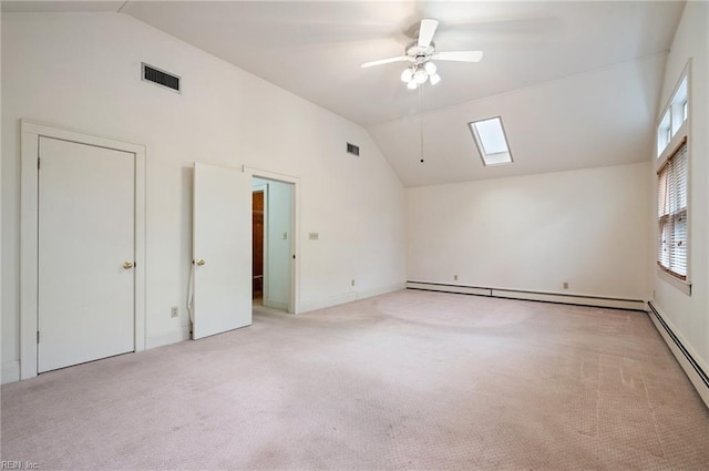 unfurnished room featuring light carpet, a baseboard radiator, lofted ceiling with skylight, and ceiling fan