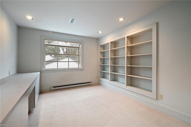 interior space featuring light colored carpet and a baseboard heating unit