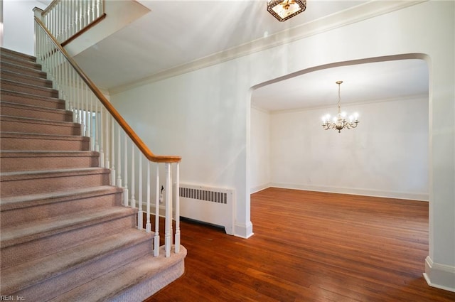 stairs featuring ornamental molding, radiator heating unit, and hardwood / wood-style floors