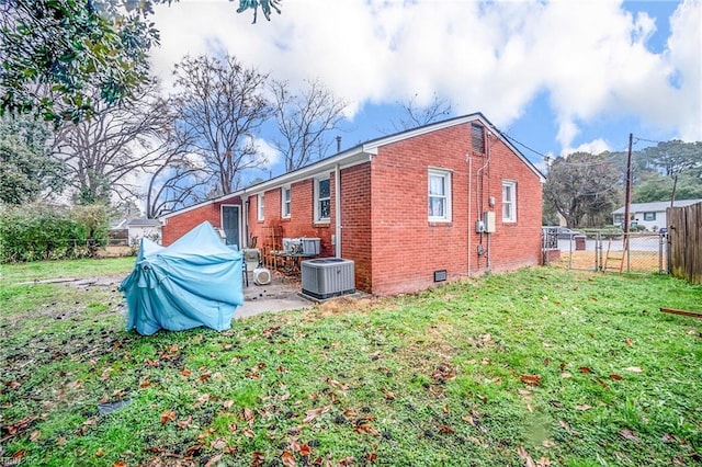 view of side of home featuring a patio, a yard, and central AC unit