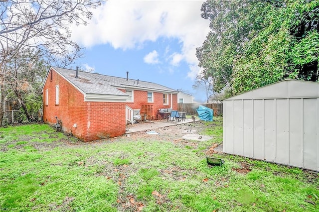 back of house featuring a storage unit, a patio area, and a lawn