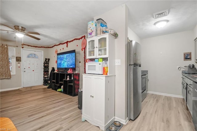 kitchen with white cabinetry, ceiling fan, appliances with stainless steel finishes, and light hardwood / wood-style floors