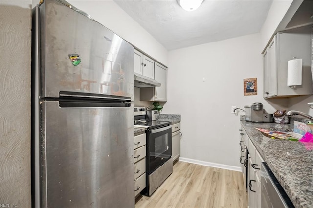 kitchen featuring sink, light hardwood / wood-style flooring, stainless steel appliances, and stone counters