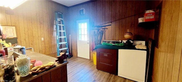 interior space featuring light hardwood / wood-style flooring, washing machine and dryer, and wood walls