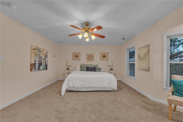 bedroom with ceiling fan and light carpet