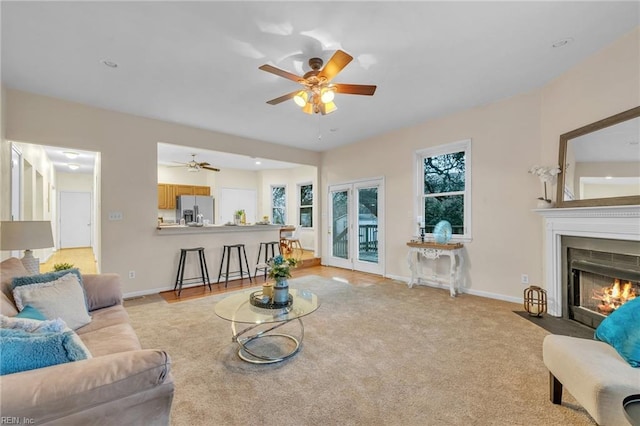 carpeted living room with ceiling fan