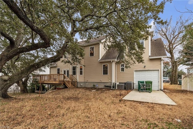 back of property featuring central AC unit, a garage, a deck, and a patio area