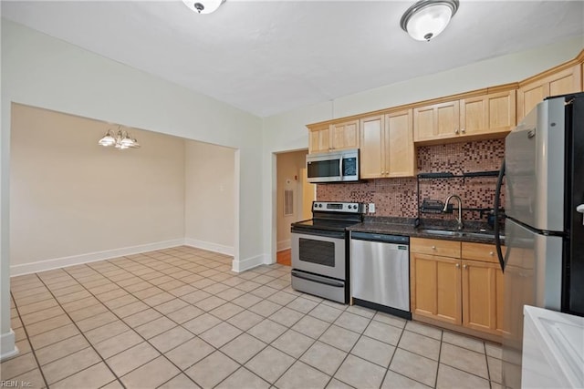 kitchen featuring sink, light tile patterned floors, appliances with stainless steel finishes, tasteful backsplash, and light brown cabinetry