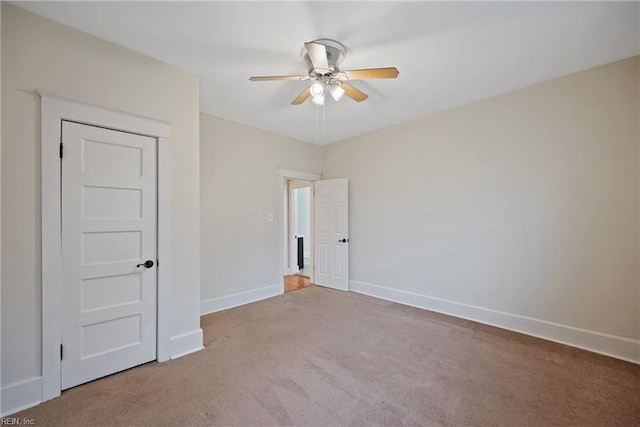 carpeted spare room with ceiling fan