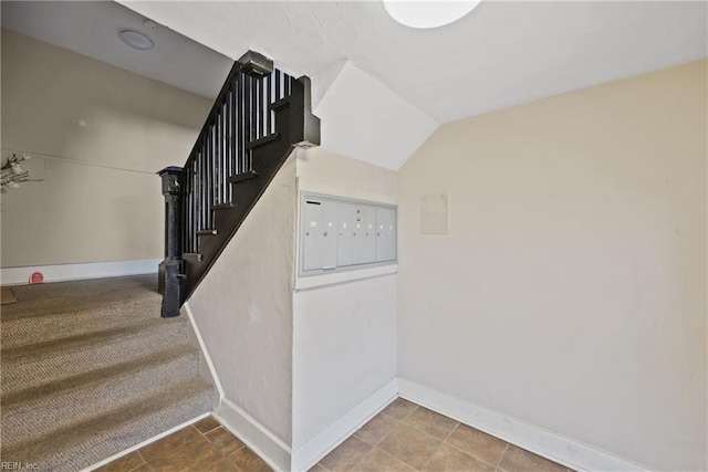 stairs featuring lofted ceiling and mail boxes